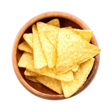 Tahta bir kasede tortilla cipsi. Klasik, gevrek atıştırmalıklar, mısır tortillasından yapılmış, üçgen şeklinde dilimler halinde kesilmiş, yağda kızartılmış ve hafif tuzlu. Yakından, yukarıdan, izole edilmiş, yemek fotoğrafı..