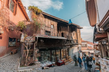 Ankara-Türkiye, 09 Aralık 2022: Ankara Kaleici 'deki eski yerleşim alanı olan pazarda alışveriş yapan, fotoğraf çeken insanlar. Sokakta ünlü antik ahşap evler. 