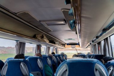 View of the passengers inside a stage coach bus. Bus interior trip. Transport, tourism, road trip and people concept.
