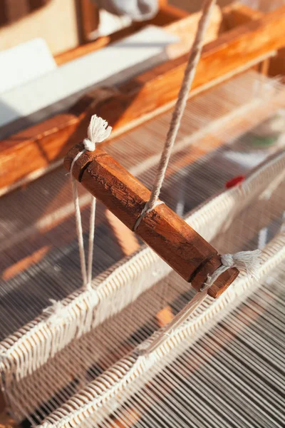 Detail of weaving equipment on the antique wooden loom and thread weaving shuttle. Handicraft textile cloth weave with traditional tools.