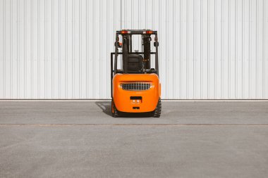Forklift, hangarın kapısına park etmiş güvenilir bir yükleyici. Sanayi aracı.
