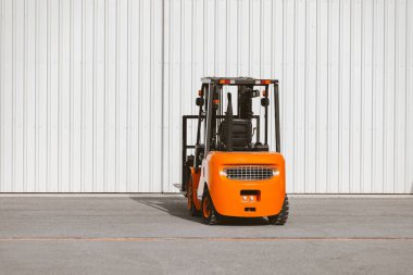 Forklift, hangarın kapısına park etmiş güvenilir bir yükleyici. Sanayi aracı.
