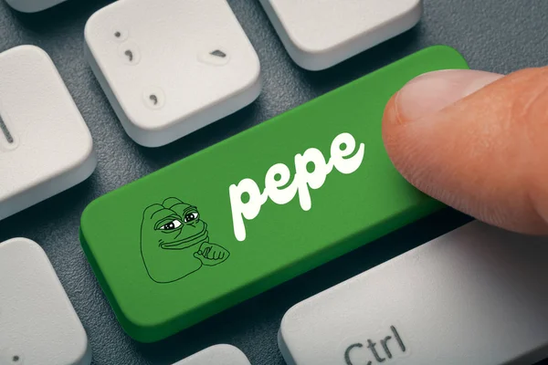 Erkek el parmağının klavyedeki pepe memecoin bilgisayar tuşuna bastığı fotoğrafı kapat. Kripto para birimi madenciliği veya ticaret konsepti.