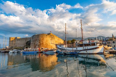 Kyrenia Limanı 'nın güzel manzarası, Girne Limani, antik kale ve Kuzey Kıbrıs' ta güneşli bir günde rıhtıma yanaşmış tekneler. Kyrenia İngilizce, Almanca, Rusça ve Türkçe turistler için popüler bir yer.