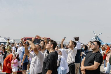 Ankara-Türkiye: 02 Eylül 2023: F-16 Fighting Falcon 'un hava gösterisini meraklı gözlerle izleyen ve Teknofest Ankara' da fotoğraf çeken heyecanlı kalabalık 