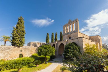 Kuzey Kıbrıs 'taki tarihi Bellapais Manastırı' nın güneşli bir günde geniş açılı fotoğrafı.