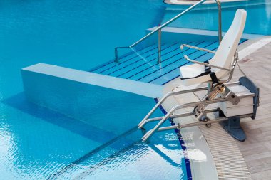 Açık havuzda engelli insanlar için havuz temizleme cihazı. Fizik tedavi konsepti.