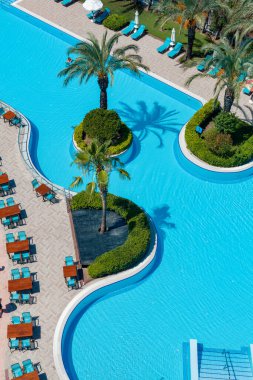 Antalya, Türkiye-27 Haziran 2021: Yeşilliklerle çevrili güzel bir yüzme havuzunun yukarısından çekilen fotoğraf.