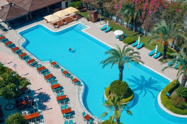 Antalya, Türkiye-27 Haziran 2021: Yeşilliklerle çevrili güzel bir yüzme havuzunun yukarısından çekilen fotoğraf.