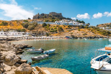 Deniz manzarası, sahil ve Lindos 'taki Akropolis. Kasaba meydanına giden yolda yürüyen turistler. 