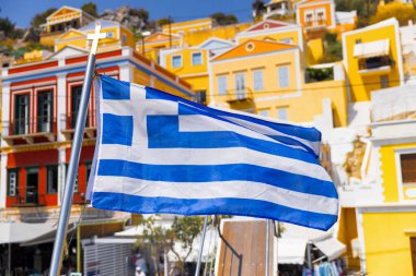 Yunanistan 'ın Yunanistan' daki renkli simge mimarisi oy Symi Adası 'nda dalgalanan bayrak.