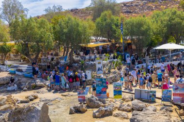 LINDOS-GREECE: 26 Ağustos 2024: Plajı geçen ve güzel Lindos sokaklarına giren turistler. Keşfetmek. İnsanlara bilgi veren bir rehber. İnsanlar kafelerde ve plajlarda iyi vakit geçiriyor..