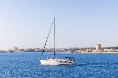 RHODES-GREECE: 26 Ağustos 2024: Turistler yelkenli teknede tatillerinin tadını çıkarıyorlar. Gezinti ve yelkenli tekne turu. İnsanlar yaz tatilinde iyi vakit geçiriyorlar..