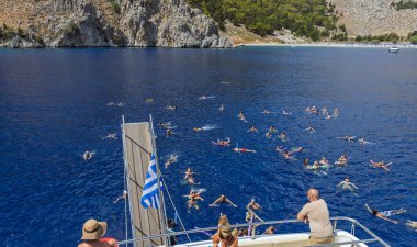 FALIRAKI, GREECE: 26 Ağustos 2024: Yunanistan 'ın Rodos adasındaki Anthony Quinn körfezinde kristal berrak denizde yüzen tatilciler. İnsanlar yazın denizde iyi vakit geçiriyorlar..