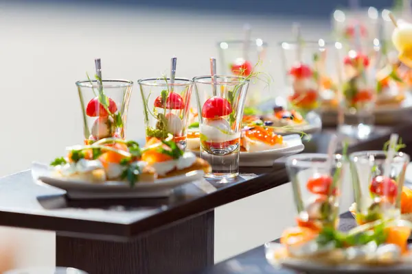catering weddings table with snacks, canape with salmon on a white plate,catering weddings table