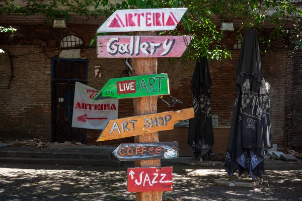 Old Town, Tiflis - Gürcistan - 06.25.2023: El yapımı Yön Tabelasında Şekillendirilmiş Tahta Ok Üzerine Yazı ve Kahve