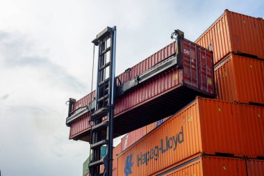 İstanbul, Beylikduzu - Türkiye - Lojistik İthalat Şirketi için 07.07.2023 konteyner sahası, renkli konteyner yığını. Yükleme anından görüntü. Vinç konteynırı tutar.