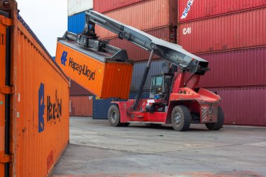 İstanbul, Beylikduzu - Türkiye - Lojistik İthalat Şirketi için 07.07.2023 konteyner sahası, renkli konteyner yığını. Yükleme anından görüntü. Vinç konteynırı tutar