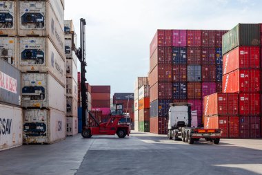 İstanbul, Beylikduzu - Türkiye - Lojistik İthalat Şirketi için 07.07.2023 konteyner sahası, renkli konteyner yığını. Yükleme anından görüntü. Vinç bir konteynır ve kamyon yükleme için bekliyor..