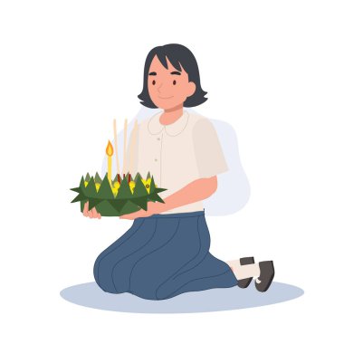 Loy Krathong Geleneksel Festivali. Taylandlı öğrenci oturuyor, kratong tutuyor ve Krathong 'u nehirde yüzdürmeye hazırlanıyor..