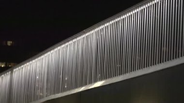 Kopenhag, Danimarka, geceleyin Fisketorv bölgesinde bisiklet otoyolunda bir çit ve bir bisikletçi..