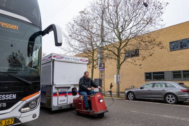 Kopenhag, Danimarka 'da bir adam küçük bir scooterlı sosisli arabasını sokağa çeker..