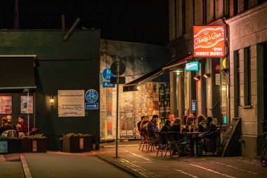 Kopenhag, Danimarka Geceleri dışarıda bir barda oturan insanlar.