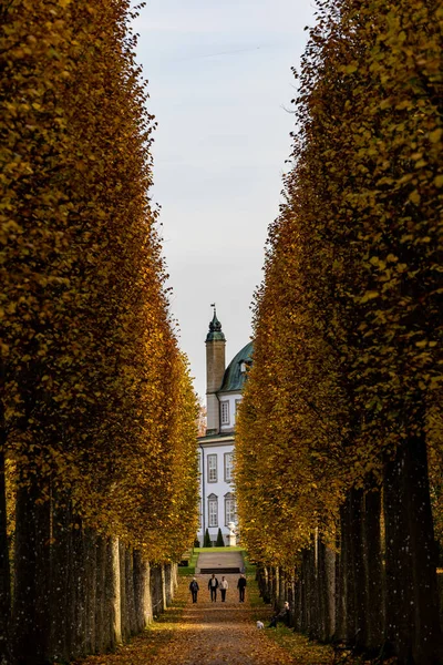 덴마크의 보르그 궁전에 바로크 정원에서 가을에 나무들 풍경을 거닐고 사람들 — 스톡 사진