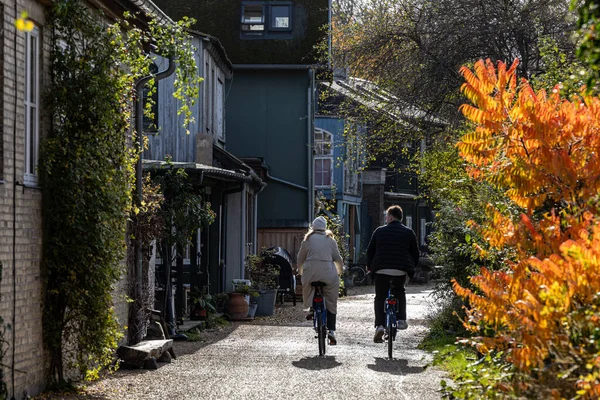 stock image Copenhagen, Denmark, A young couple ride bikes through Christiania,