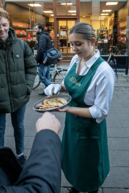 Kopenhag, Danimarka. Bir garson, La Glace 'da bir masa için sıraya giren insanlara bedava kurabiye veriyor..