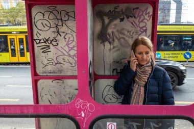 Budapeşte, Macaristan Eski bir telefon kulübesinde bir kadın cep telefonuyla konuşuyor.