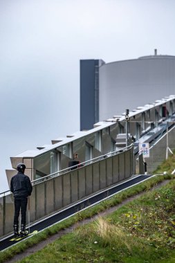 Kopenhag, Danimarka. Kayakçı, Kopenhag kayak alanında kayak asansörüne biniyor. Kayak pisti şehrin buz pateni ve elektrik santrali olarak ikiye katlanıyor..