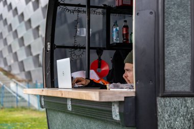 Kopenhag, Danimarka. Bir kayak biletçisi bir kabinin içinde bilgisayara bakıyor..