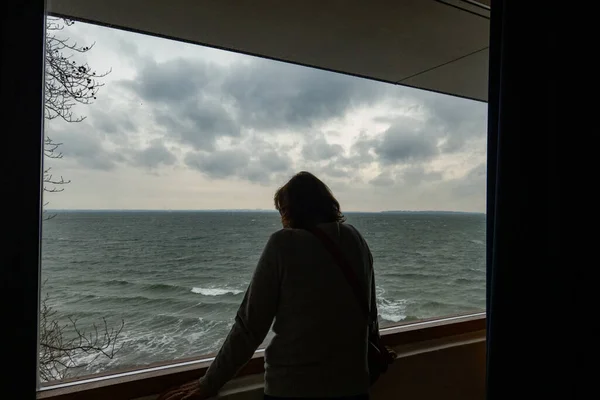 コペンハーゲン デンマークルイジアナ博物館への女性の訪問者は 海とスウェーデンへのオレンジ色の海峡を見ています — ストック写真