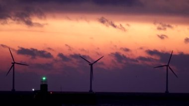 Kopenhag, Danimarka Rüzgar türbinleri şafak vakti Öresund Boğazı üzerinde bir gemi geçerken dönüyor.  