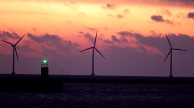 Kopenhag, Danimarka Rüzgar türbinleri Öresund Boğazı üzerinde şafak vakti dönüyor.