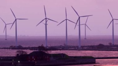Kopenhag, Danimarka Rüzgar türbinleri Öresund Boğazı üzerinde şafak vakti dönüyor.