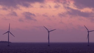 Kopenhag, Danimarka Rüzgar türbinleri Öresund Boğazı üzerinde şafak vakti dönüyor.