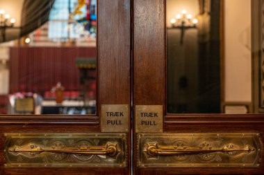 Copenhagen, Denmark  A wooden door with Danish and English writing to pull, in the Copenhagen City Hall.