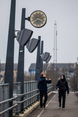 Copenhagen, Denmark  Two young men walk an overpass in the suburb of Hoje Taastrup over the tracks.
