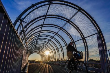 Copenhagen, Denmark Pedestrians on a covered bridge over the railway track in the Amager district.
