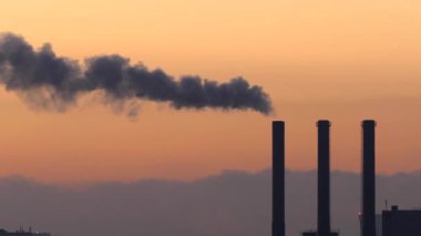 Copenhagen, Denmark Smokestacks from a power plant at dawn over the skyline emit steam.