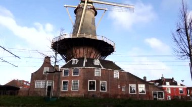 Delft, Hollanda Şehir merkezinde eski bir yel değirmeninin yanından bir tramvay geçiyor, Delft Windmill de Roos ya da Molen de Roos.