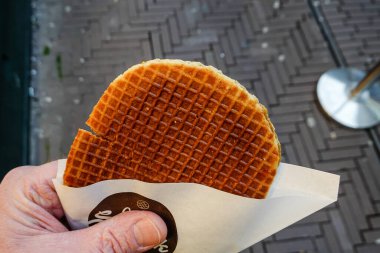 The Hague, Netherlands A hand holds a typical Dutch waffle sweet treat called a Stroopwafel.