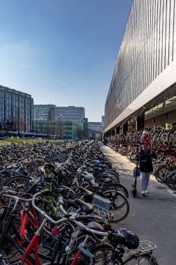 Rotterdam, Netherlands  A man carries his daughter through rows of bicycles parked at the Rotterdam Central Station.