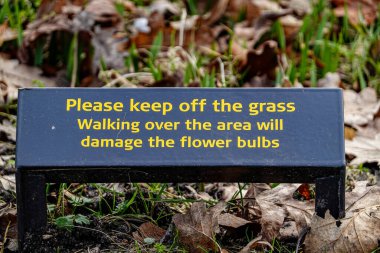 Copenhagen, Denmark,  A keep off the grass sign in English in the Frederiksberg Gardens.
