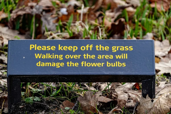 Copenhagen, Denmark,  A keep off the grass sign in English in the Frederiksberg Gardens.