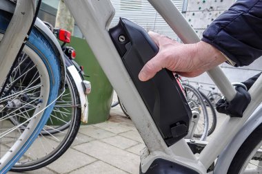 Copenhagen, Denmark A man slides a bicyle battery onto a n electric bicycle.