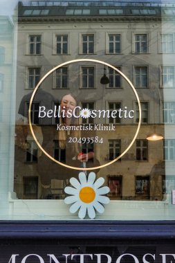 Copenhagen, Denmark A woman washes the interior window of a cosmetics clinic.