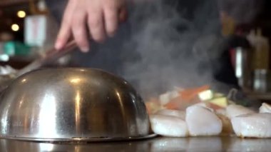 Bir şef Hibachi ve Teppanyaki ızgarasında Japon yemeği hazırlıyor.. 